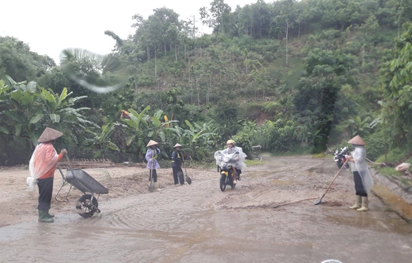 Công nhân thu dọn bùn đất trên Quốc lộ 70.