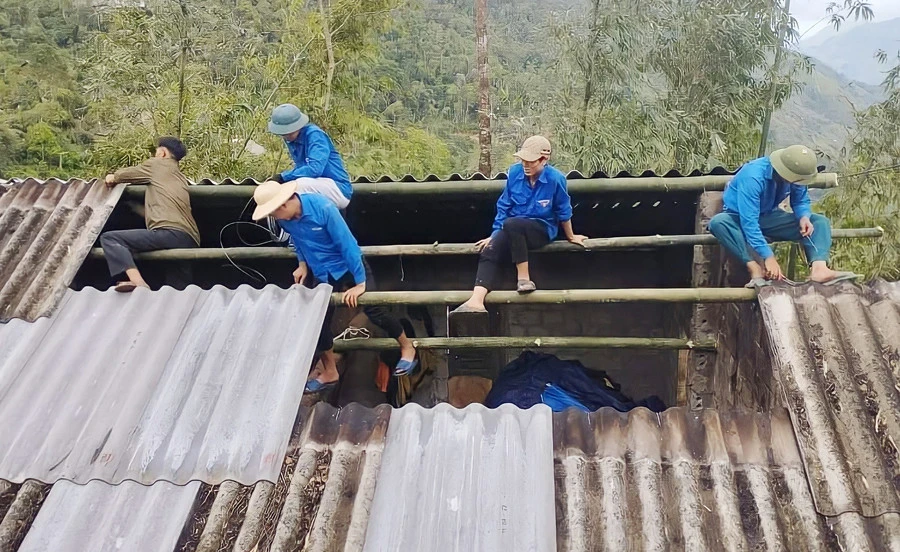 Thanh niên xã Thanh Bình giúp người dân lợp lại nhà sau đợt thiên tai.
