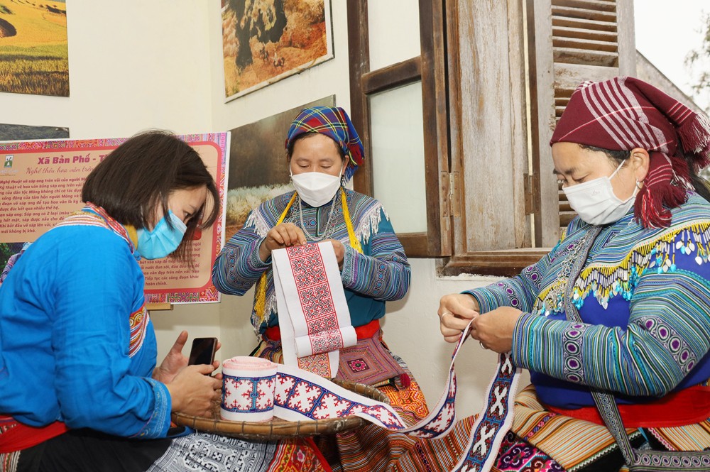 Bà Vàng Thị Cở (giữa ảnh) trình diễn thêu hoa văn trang phục người Mông hoa tại Lễ hội mùa Đông huyện Bắc Hà.