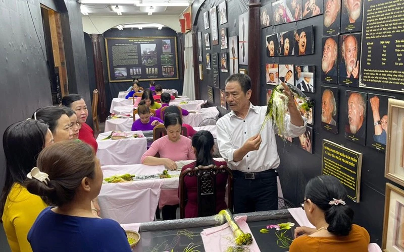 Anh Võ Văn Quân và các nghệ nhân thêu XQ trao đổi về chủ đề tác phẩm một bức tranh thêu.