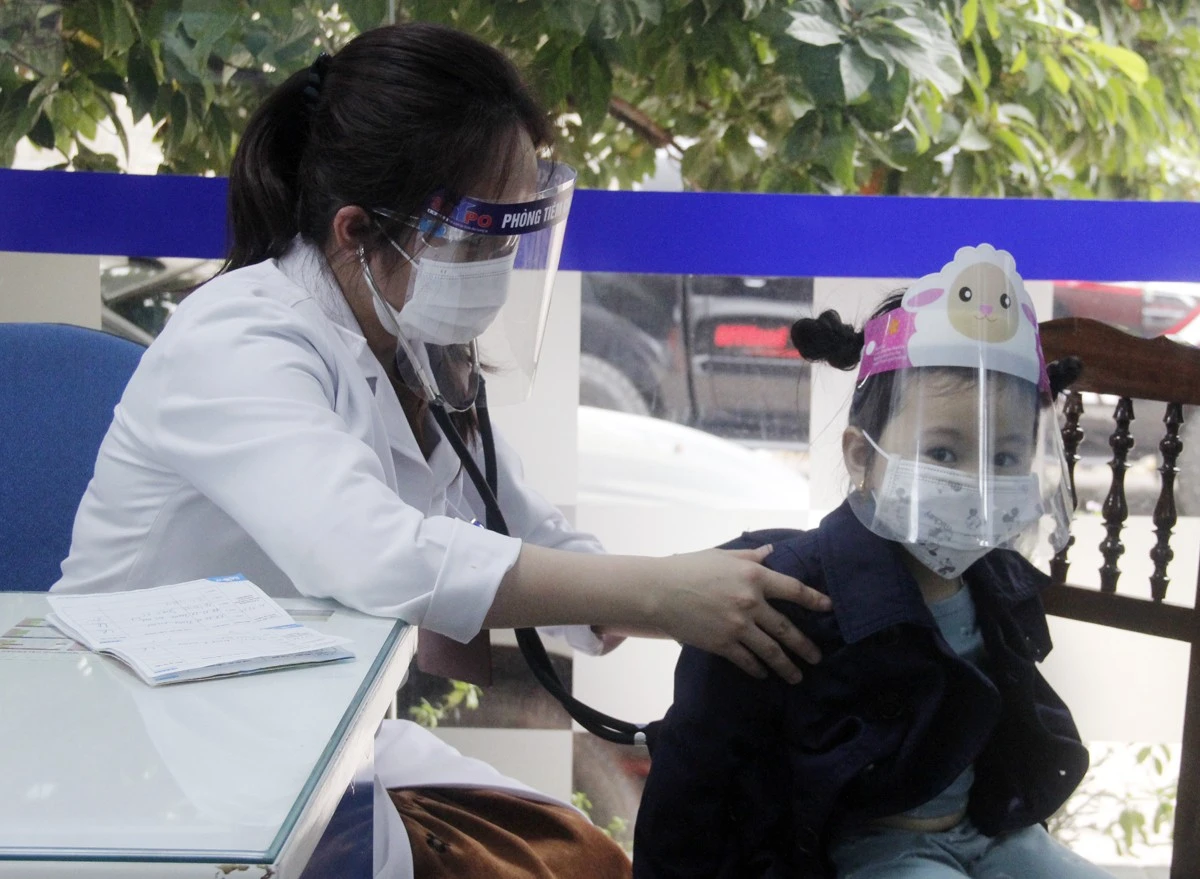 Trẻ được đeo khẩu trang, kính chắn giọt bắn khi đến tiêm chủng.