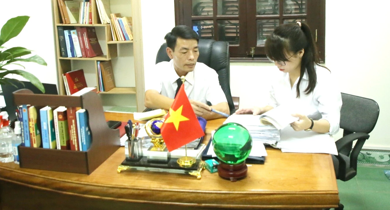 Thẩm phán và thư ký nghiên cứu hồ sơ vụ án tranh chấp đất đai.