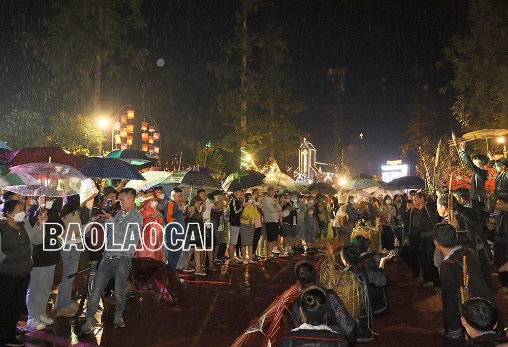 Du khách đội mưa xem biểu diễn.