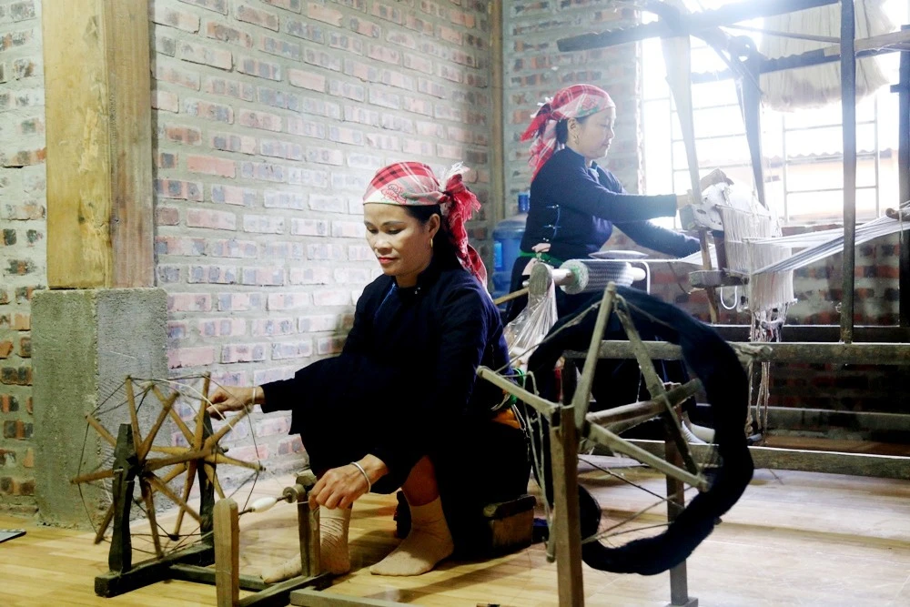 Phụ nữ Tày ở Làng Giàng duy trì nghề dệt vải thêu thổ cẩm.