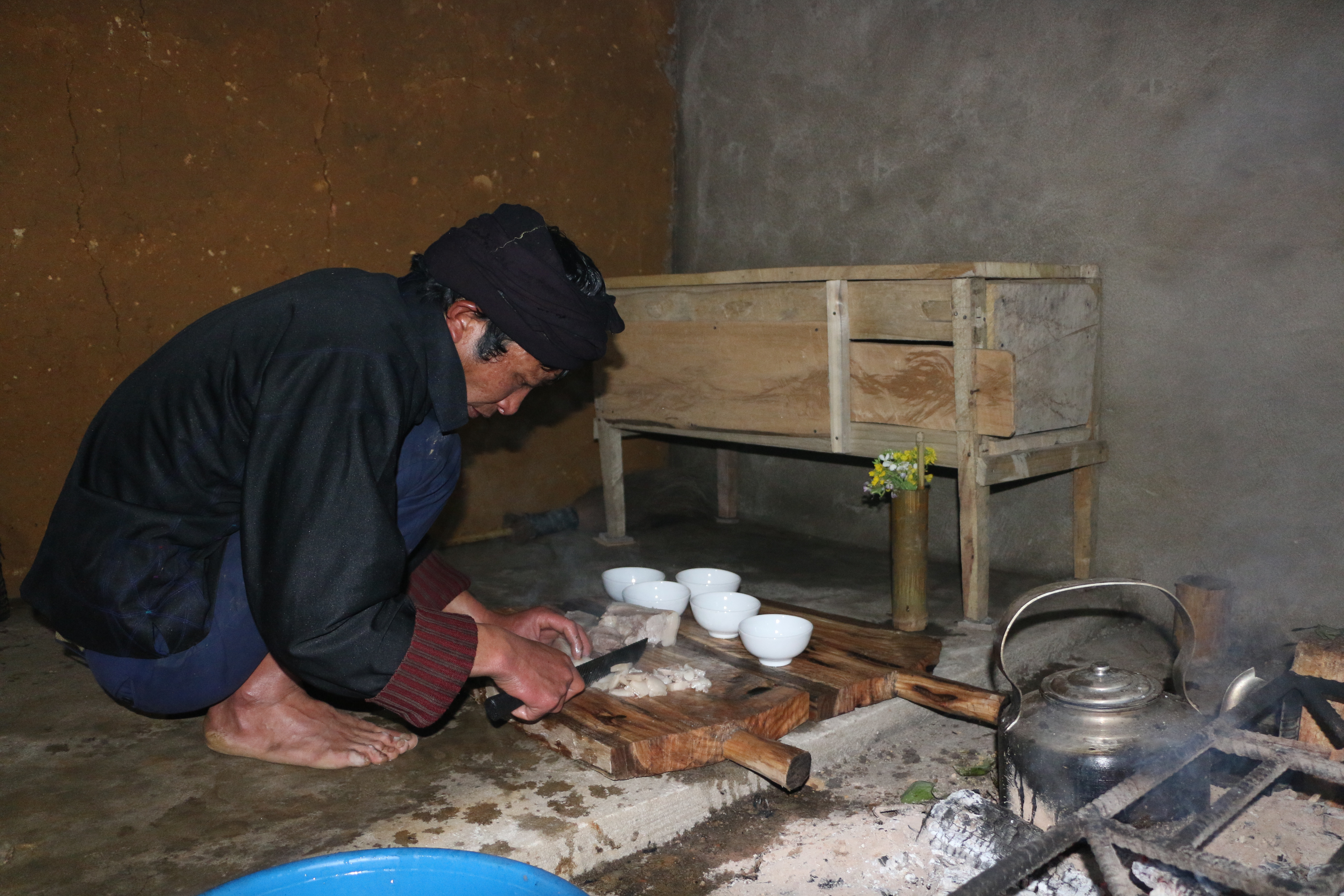 Chủ nhà gùi củi vào nhà mới.