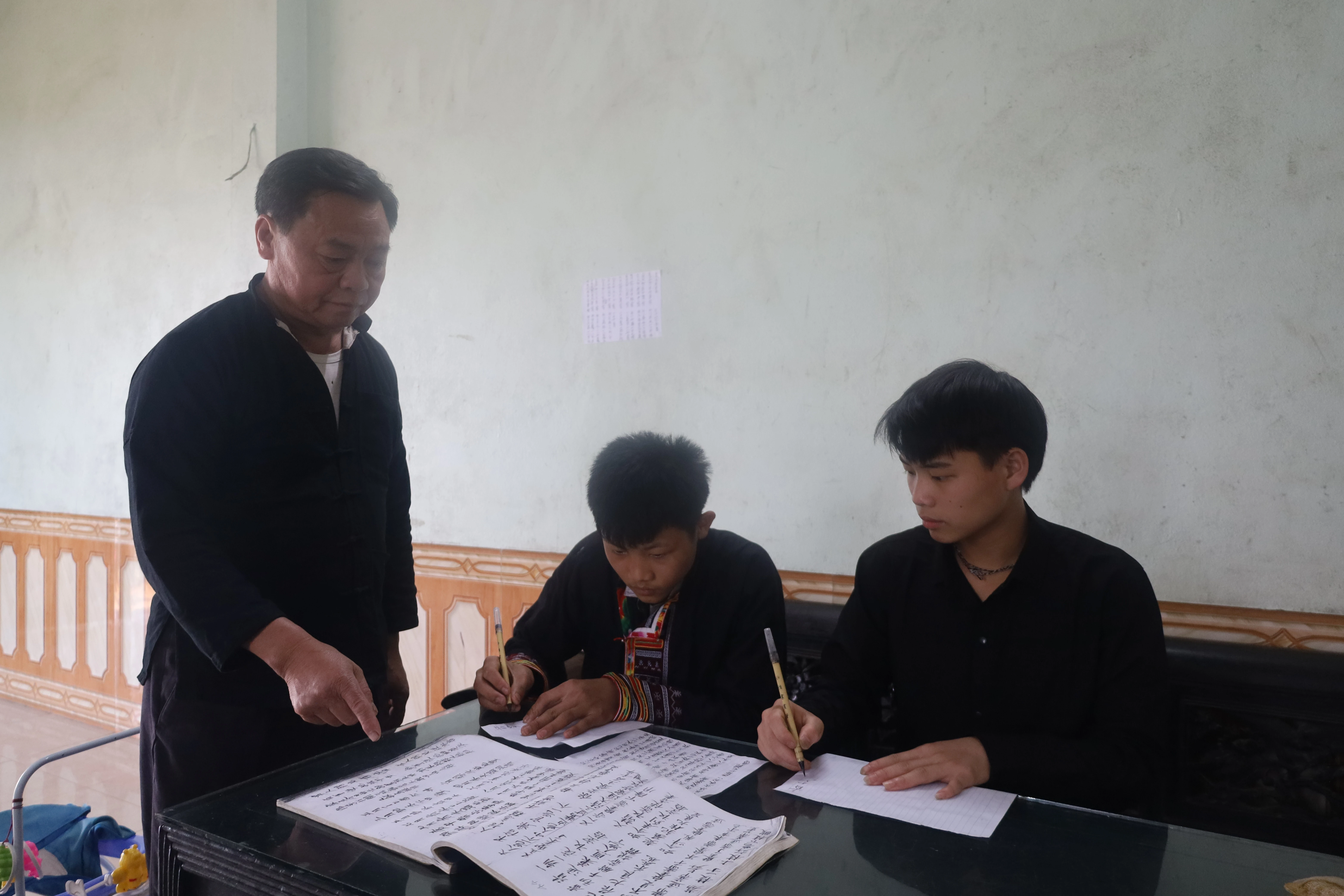 Ông Triệu Kim Vảng dạy chữ nôm Dao cho con cháu trong dòng họ.