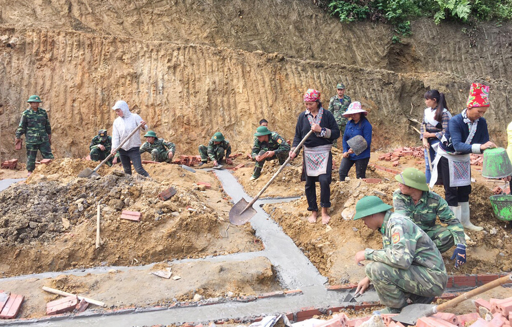 Cán bộ, chiến sĩ Đồn Biên phòng A Mú Sung giúp dân làm nhà.