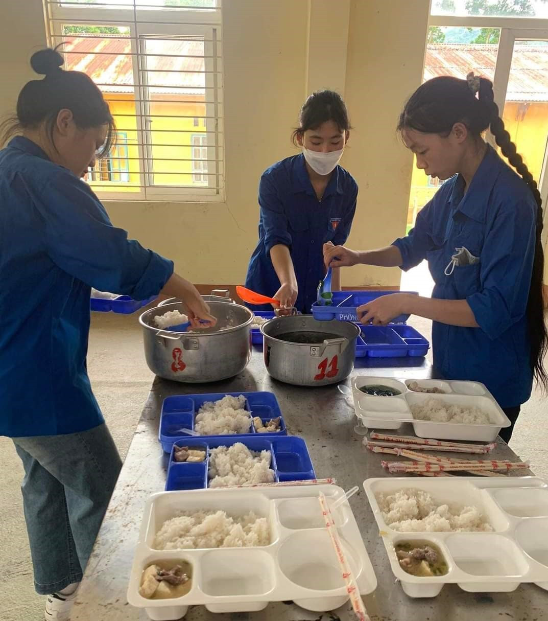 Các tình nguyện viên chuẩn bị bữa cơm cho thí sinh ở xa tại Hội đồng coi thi THPT số 2 huyện Bát Xát.