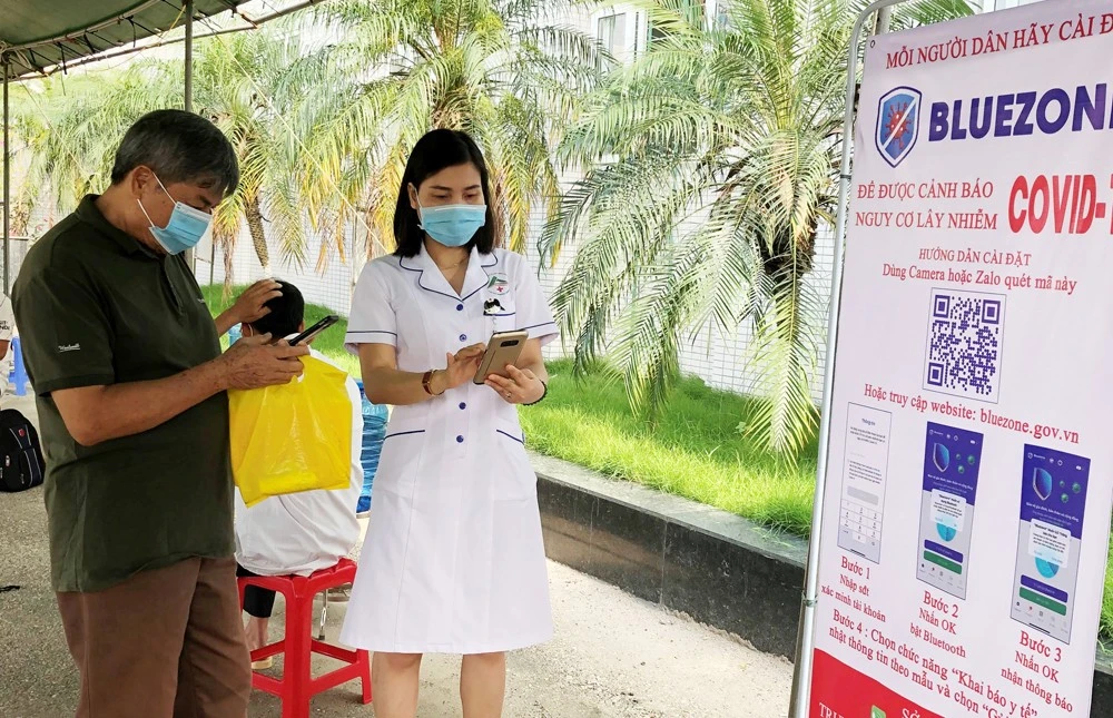 Chị Hồng hướng dẫn người bệnh khai báo y tế.