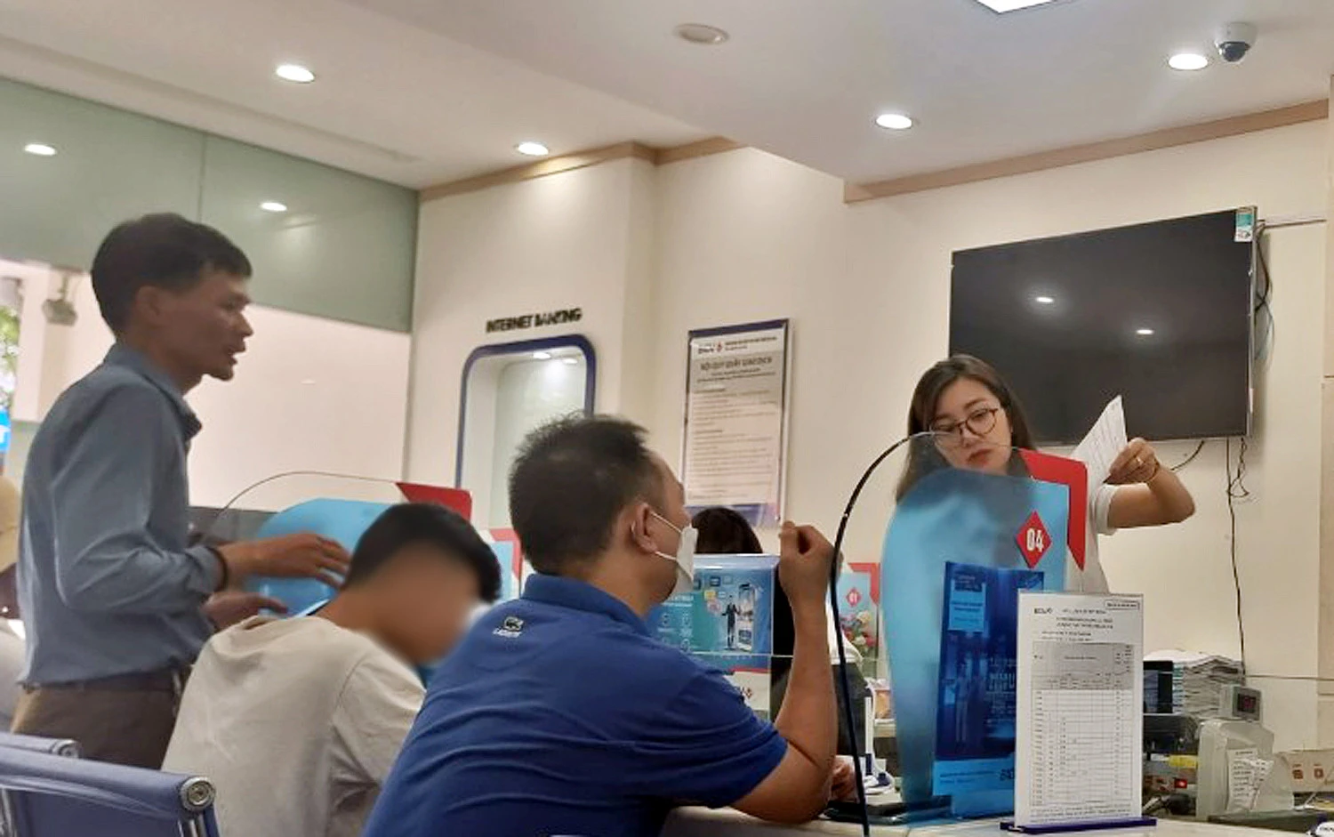 Cháu Đỗ Văn K làm thủ tục đóng tài khoản ngân hàng online tại điểm giao dịch của ngân hàng tại thành phố Lào Cai.