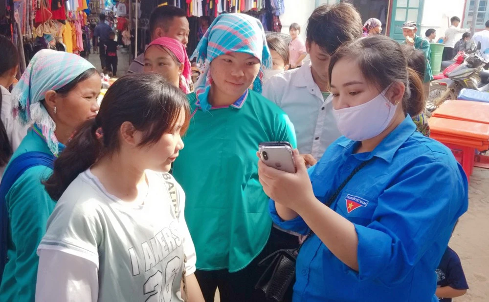 Đảng viên trẻ Giàng Thị Linh vận động người dân cài ứng dụng “Sổ sức khỏe điện tử” trên điện thoại di động.