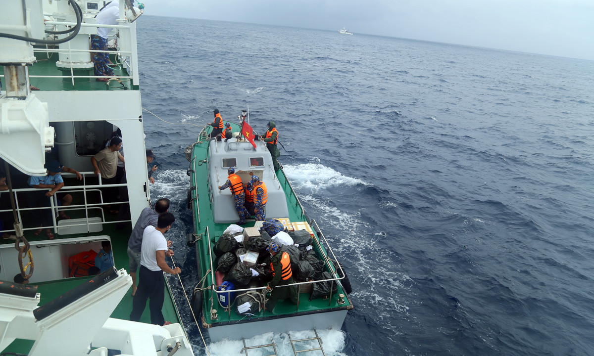 Chuyển hàng tết từ tàu 490 xuống xuồng và tàu Vạn Hoa để chuyển vào đảo Song Tử Tây.