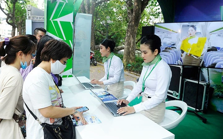 Khách hàng đặt mua vé máy bay trên điện thoại di động tại lễ hội du lịch và văn hóa ẩm thực Hà Nội năm 2021 - ảnh chụp trước khi dịch Covid-19 bùng phát lần thứ tư. Khách hàng đặt mua vé máy bay trên điện thoại di động tại lễ hội du lịch và văn hóa ẩm thực Hà Nội năm 2021 - ảnh chụp trước khi dịch Covid-19 bùng phát lần thứ tư.