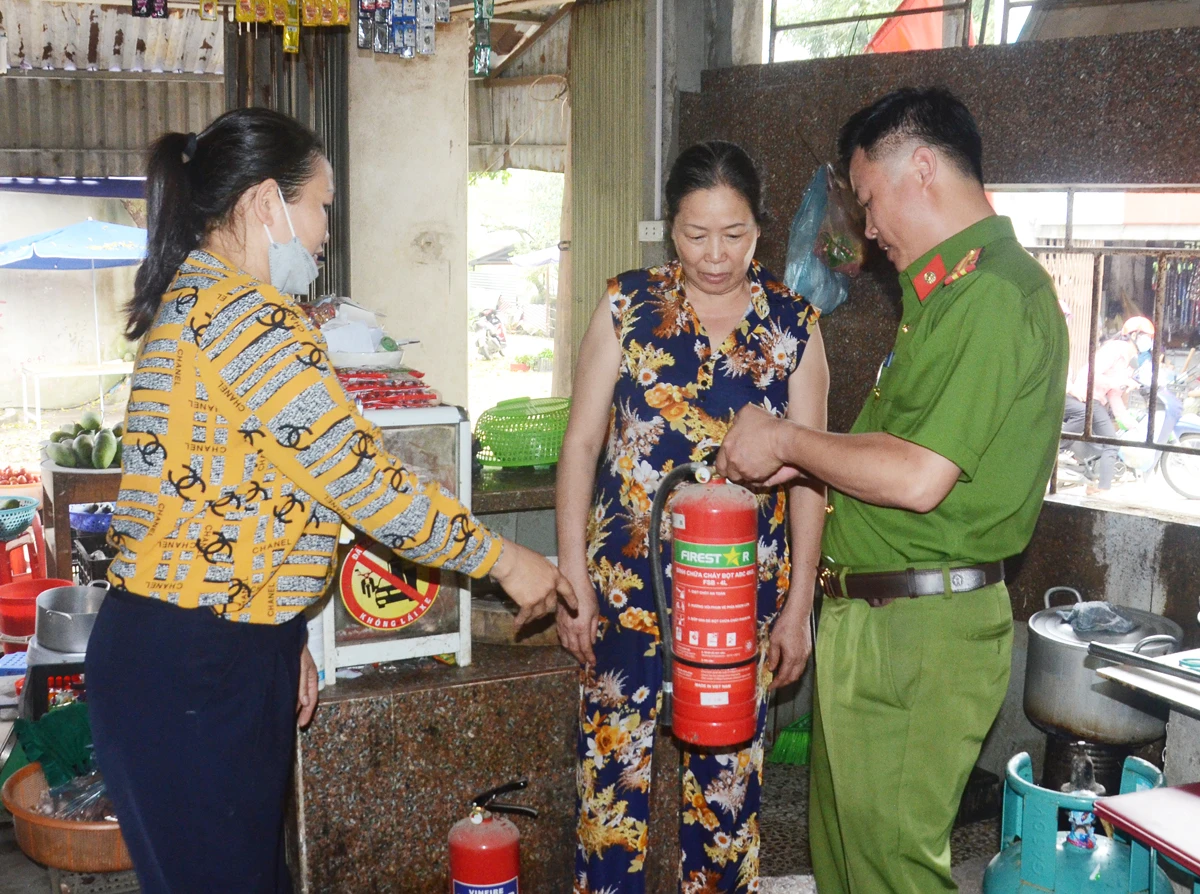 Công an thành phố và dân phòng cơ sở tuyên truyền cho hộ có nhà ở kết hợp kinh doanh trang bị bình phun chữa cháy.