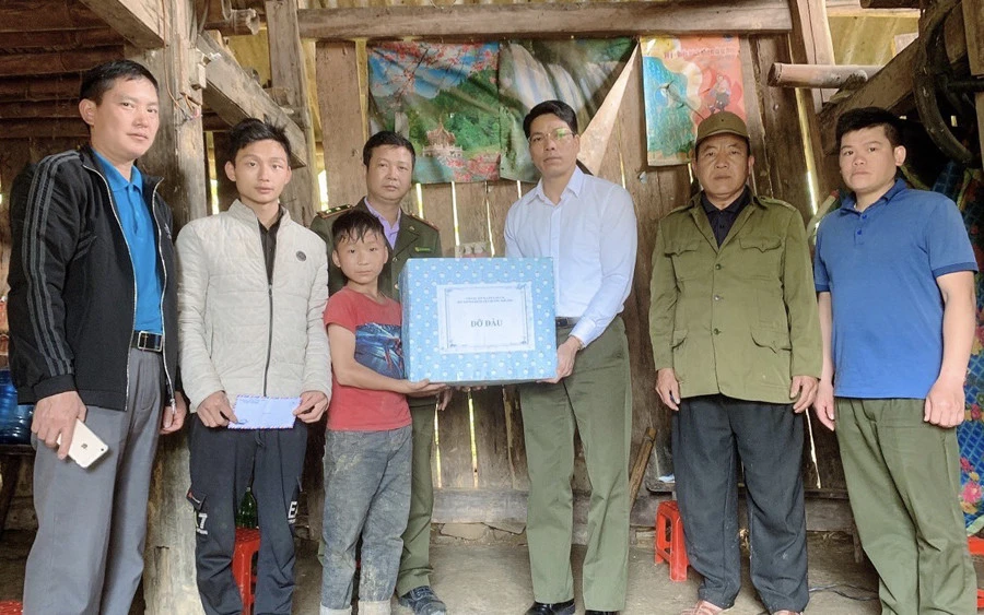 Cán bộ Hạt Kiểm lâm huyện Mường Khương tặng quà em Giàng Sinh.