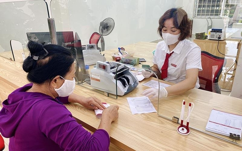 Áp lực với lãi suất cho vay ảnh 1 Khách hàng gửi tiền tiết kiệm tại một chi nhánh Agribank.