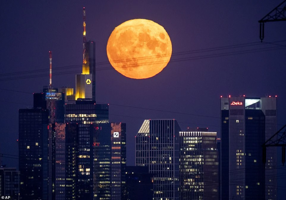 Mặt trăng như thể đang treo lơ lửng bên trên các tòa nhà chọc trời ở Frankfurt, Đức.