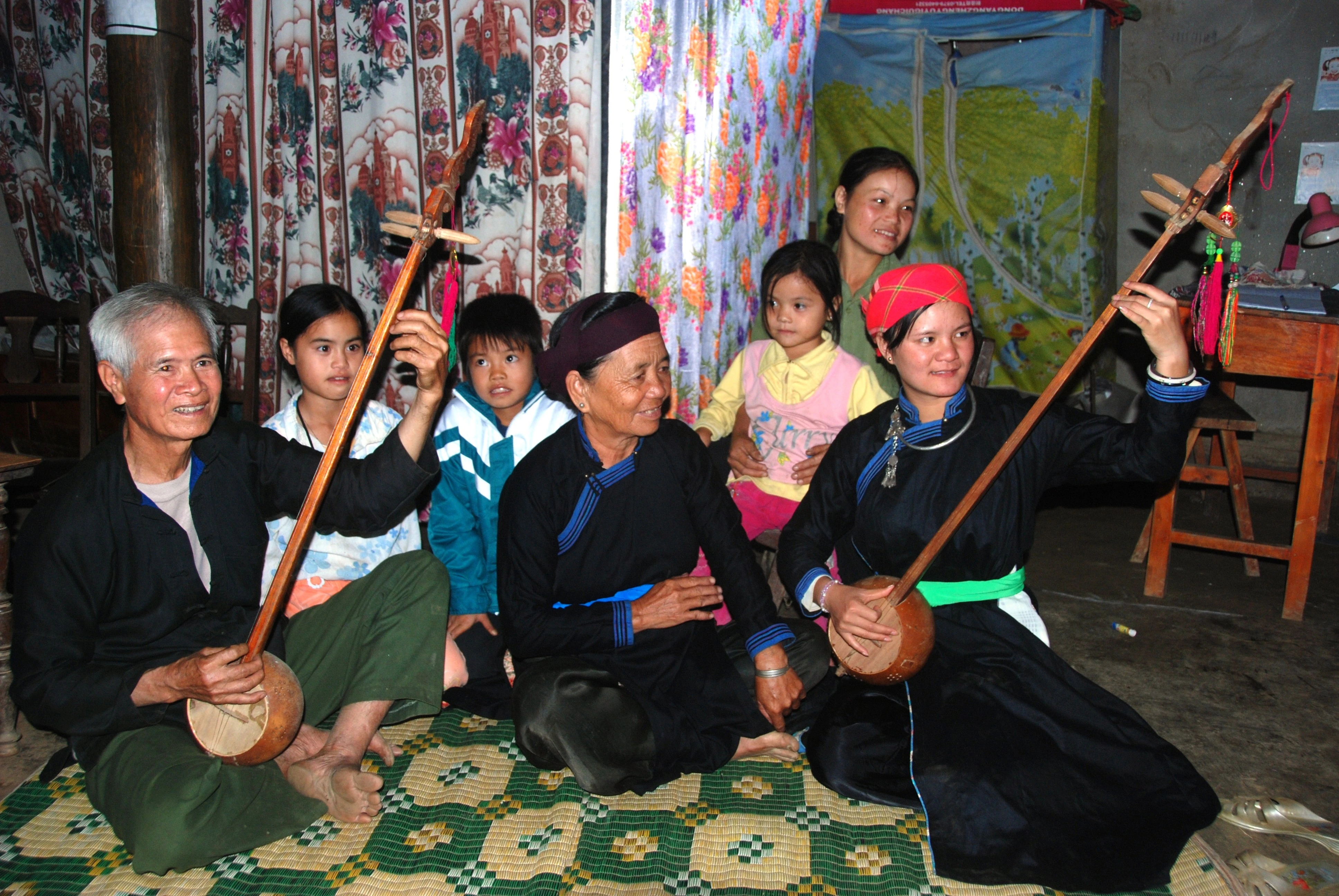 Nghệ nhân Lâm Văn Lù truyền dạy sử dụng đàn tính cho con, cháu.