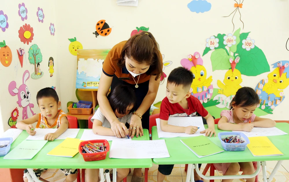 Cô giáo Trường Mầm non Cốc San chăm sóc trẻ mầm non 4 tuổi.