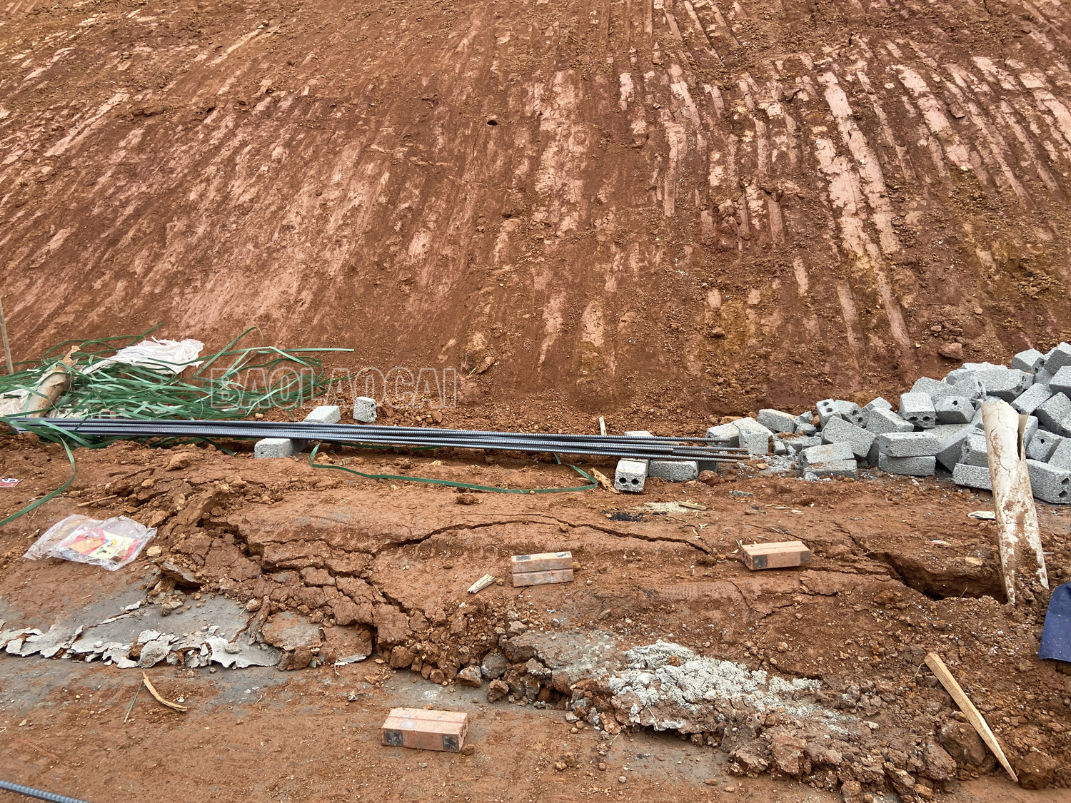 Vệt nứt ta luy nguy hiểm đang ngày một to hơn. Phía chân ta luy bị đẩy lên do đất trượt xuống. Phía sau các căn nhà mới san gạt đất.