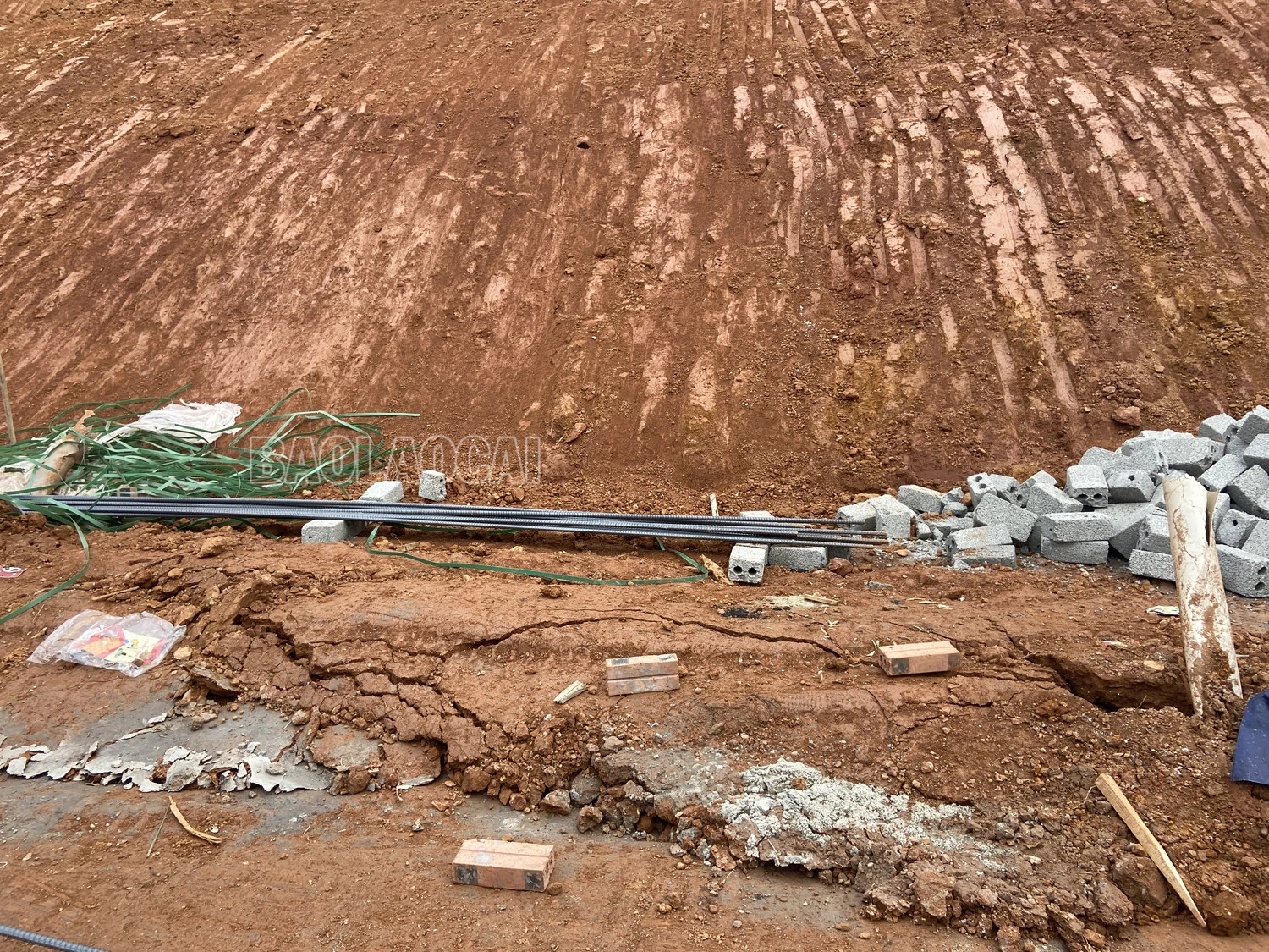 Vệt nứt ta luy nguy hiểm đang ngày một to hơn. Phía chân ta luy bị đẩy lên do đất trượt xuống. Phía sau các căn nhà mới san gạt đất.