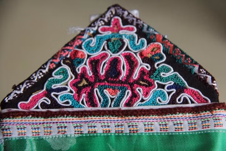 Miếng vải làm đai buộc dây trên tạp dề có thêu hoa văn hình con rồng. Miếng vải làm đai buộc dây trên tạp dề có thêu hoa văn hình con rồng.