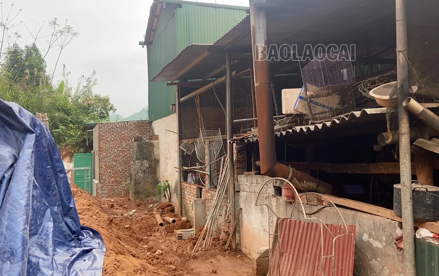 Vệt nứt ta luy nguy hiểm đang ngày một to hơn. Phía chân ta luy bị đẩy lên do đất trượt xuống. Phía sau các căn nhà mới san gạt đất.