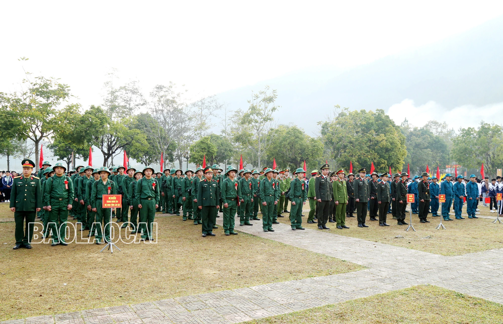 Các tân binh và đông đảo người thân, các em học sinh đến tiễn tân binh lên đường nhập ngũ.