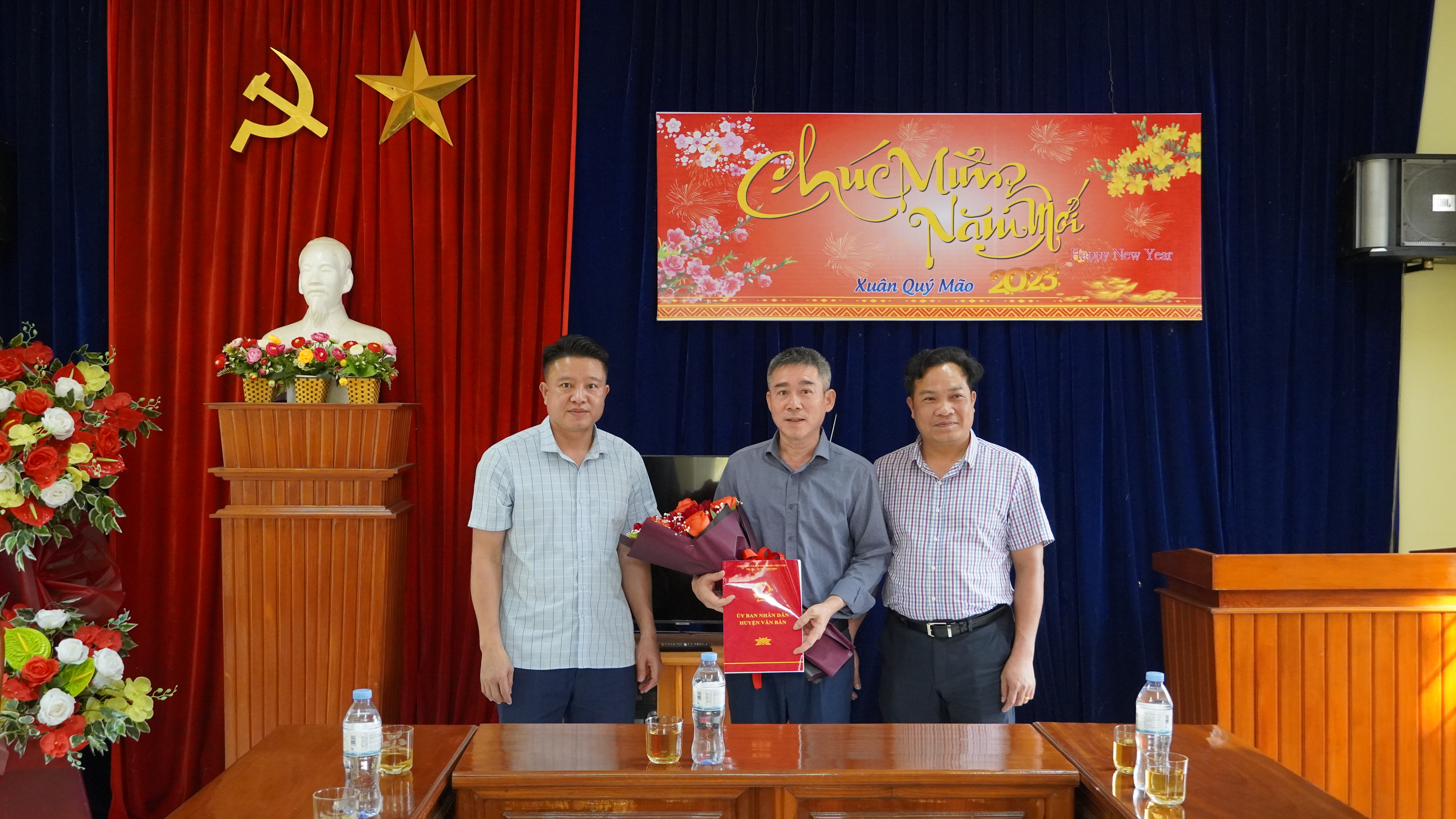 Đồng chí Lương Thanh Hương, Phó Chủ tịch UBND huyện Văn Bàn trao quyết định và tặng hoa chúc đồng chí Bùi Văn Hưng, Giám đốc Trung tâm Văn hóa, Thể thao - Truyền thông huyện.