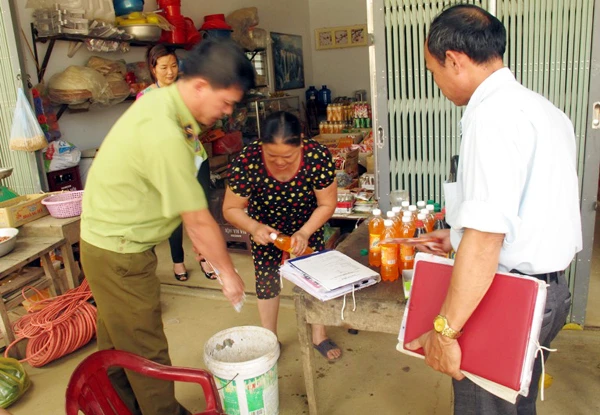 Đoàn kiểm tra yêu cầu cơ sở kinh doanh tiến hành tiêu hủy sản phẩm nước đóng chai hết hạn sử dụng.