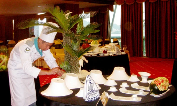 Đầu bếp bài trí món ăn trên bàn tiệc.