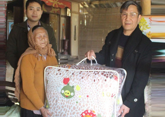 Lãnh đạo Sở Kế hoạch và Đầu tư tặng chăn ấm cho cụ Trần Thị Nuôi, thôn Tân Phong 1.