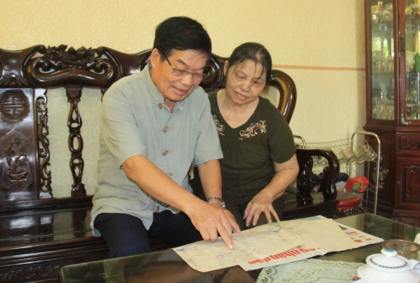 Thượng tá Trần Ngọc Giao và vợ xem lại những bài viết về chiến công của ông và đồng đội.