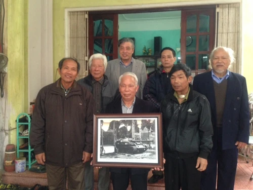 Ông Nguyễn Quang Hòa (cầm bức ảnh) và các chiến sĩ trên chiếc xe tăng 846 cùng các phóng viên TTXVN và báo Quân đội Nhân dân gặp mặt sau 40 năm.