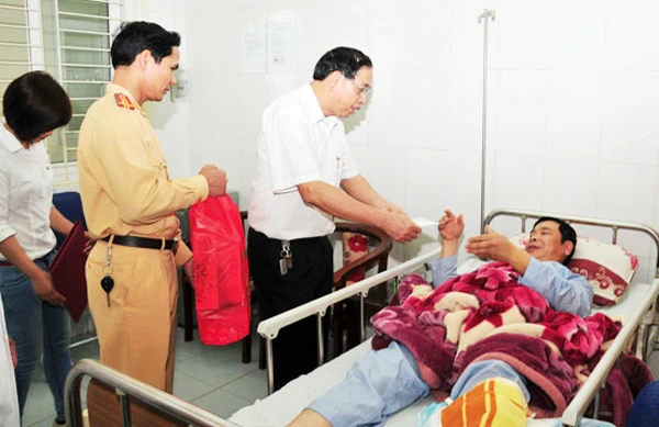 Đại diện Ban An toàn giao thông (ATGT) và lãnh đạo Phòng Cảnh sát Giao thông Công an tỉnh thăm hỏi, tặng quà Trung tá Nguyễn Văn Sáng.