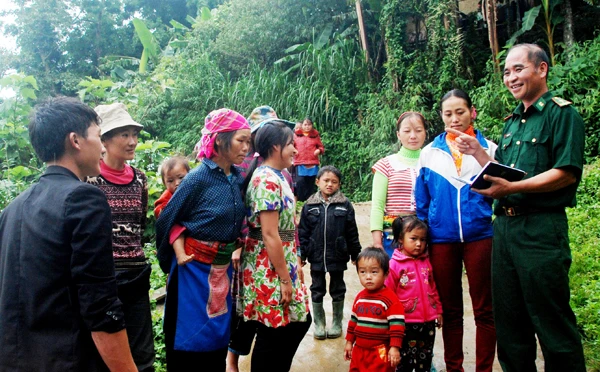 Thiếu tá Phùng Quang Tiến tuyên truyền, vận động nhân dân cho con, em đến trường.