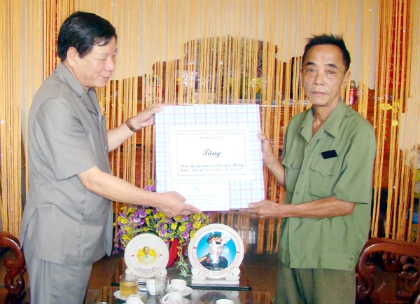 Đồng chí Phạm Văn Cường tặng quà gia đình ông Nguyễn Đức Độ, người hoạt động kháng chiến bị nhiễm chất độc hoá học 41-60%, thôn Tân An 1, xã Tân An.
