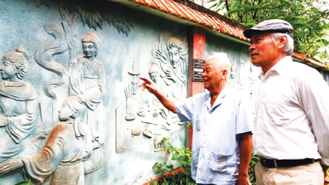 Ông Nguyễn Bá Khoát dẫn khách tham quan bức tường đắp phù điêu “Truyện Kiều”. Ông Nguyễn Bá Khoát dẫn khách tham quan bức tường đắp phù điêu “Truyện Kiều”.