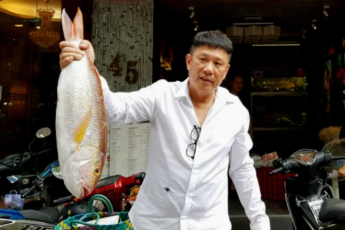 Harry Ang bên con cá to mà ông kiểm tra trong lô nguyên liệu mang đến nhà hàng.