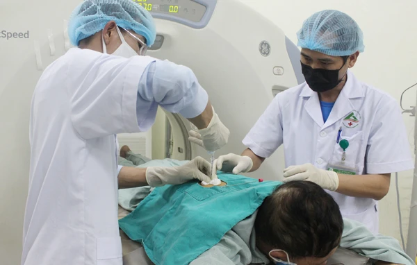 Các bác sỹ đang thực hiện kỹ thuật sinh thiết u phổi xuyên thành ngực cho bệnh nhân.