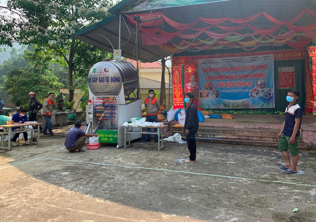 Người nhận gạo xếp hàng đúng khoảng cách quy định.