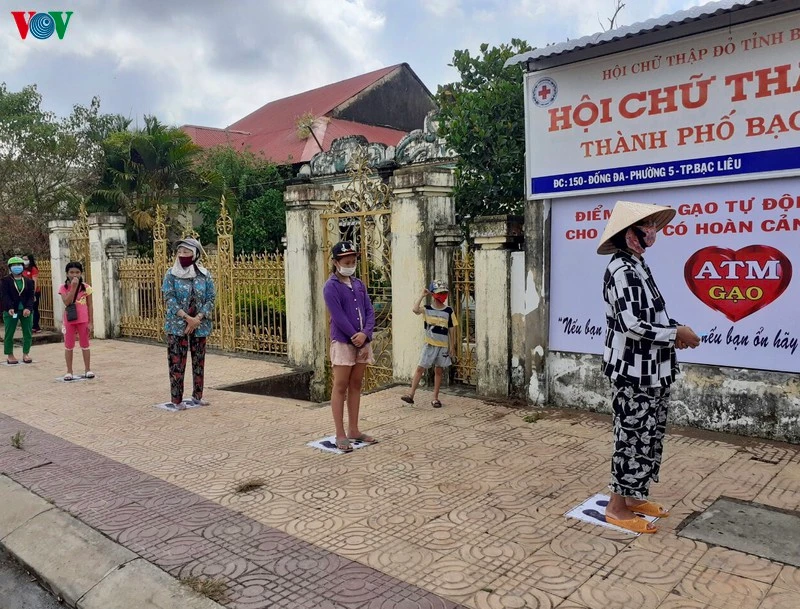 Người đến nhận gạo hỗ trợ nghiêm túc thực hiện giãn cách theo quy định.