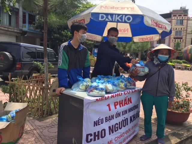 Người dân đến nhận gạo miễn phí.