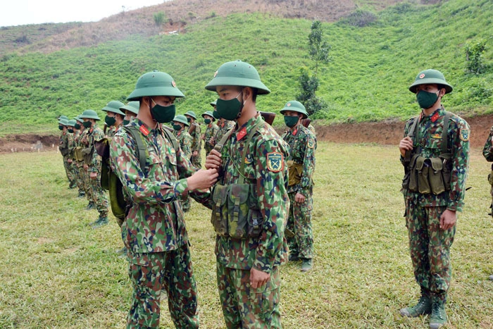 Các tiểu đội trưởng kiểm tra việc mang trang bị của các chiến sỹ trước khi thực hành huấn luyện. Cán bộ đơn vị kiểm tra đường ngắm của tân binh trong huấn luyện bắn súng.