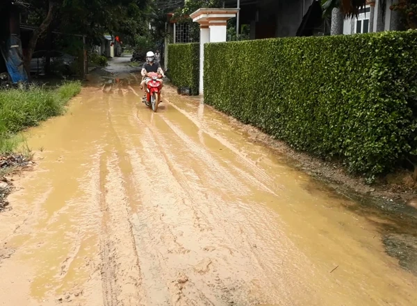 Bùn đất tràn ra đường khiến việc đi lại của người dân gặp khó khăn, nguy hiểm.