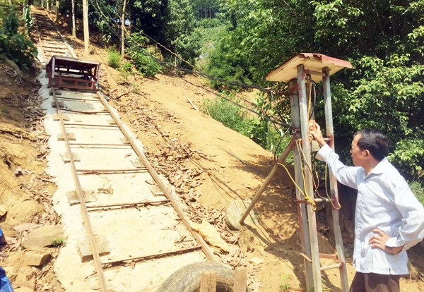 Ông Thính điều khiển xe goòng chở thức ăn chăn nuôi lên đồi.