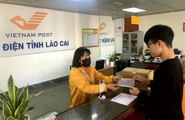 Người dân đến giao dịch tại Bưu điện tỉnh Lào Cai đều được phát khẩu trang y tế miễn phí.