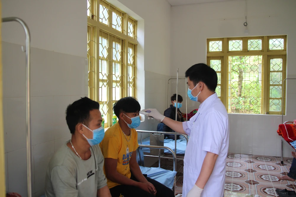 Kiểm tra thân nhiệt của người lao động từ Trung Quốc trở về.