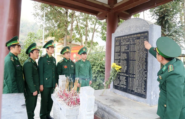 Cán bộ, chiến sỹ Đồn Biên phòng Pha Long bên Đài bia danh sách anh hùng, liệt sỹ của đơn vị.