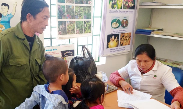 Cán bộ Trạm Y tế xã Điện Quan cho trẻ em uống thuốc tẩy giun và bổ sung vitamin B1 (ảnh chụp tháng 12/2019).